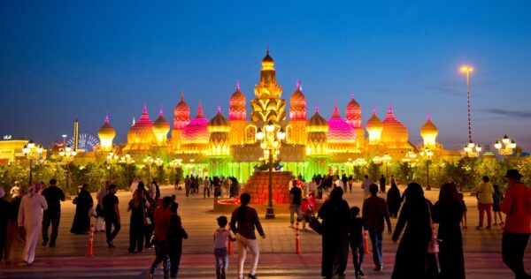 Global Village Dubai entrance with vibrant lights and international flags